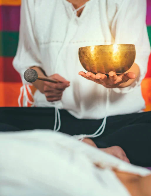 Bol tibetan atins deasupra unei persoane întinse